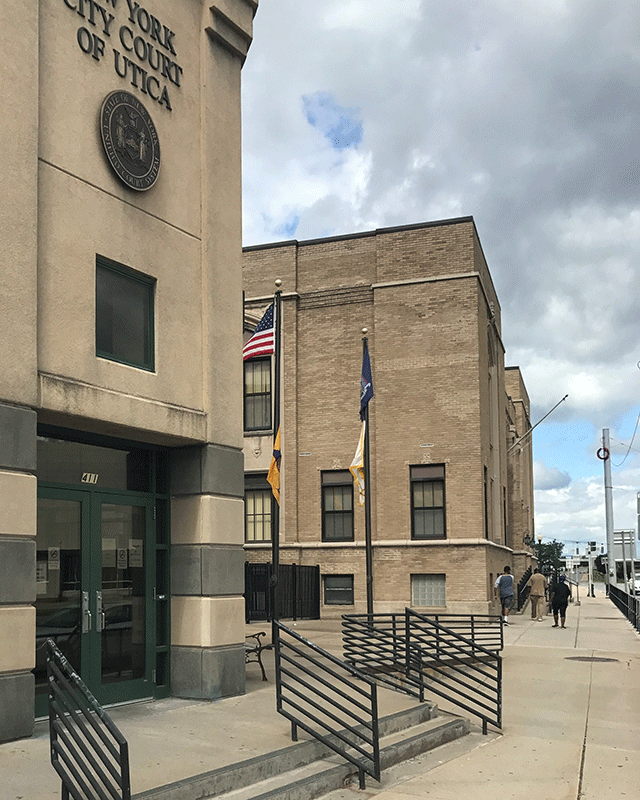 The entrance to the courthouse. There are two steps that lead to the double door entrance. To the right is a ramp that also leads to the entrance.