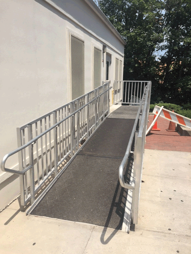 The entrance to a metal ramp that leads to the court facility. The facility is located toward the left of the ramp.