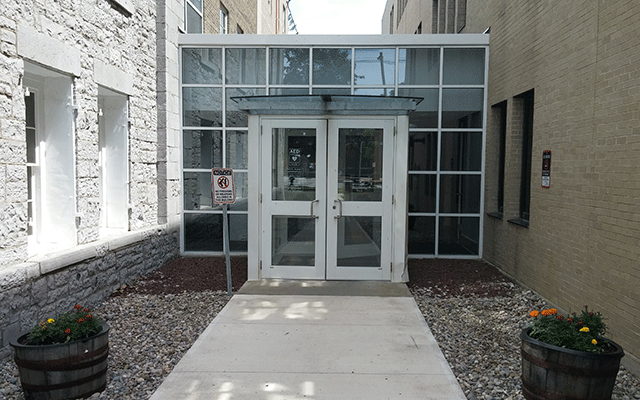 A walkway that leads to two doors, this entry area connects two buildings together.