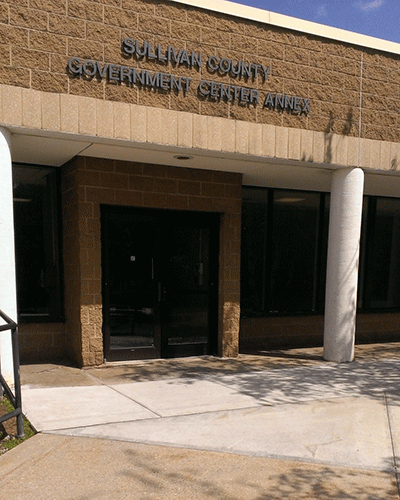 "A corner view of the courthouse with a  door to the left corner area and a window to the right."