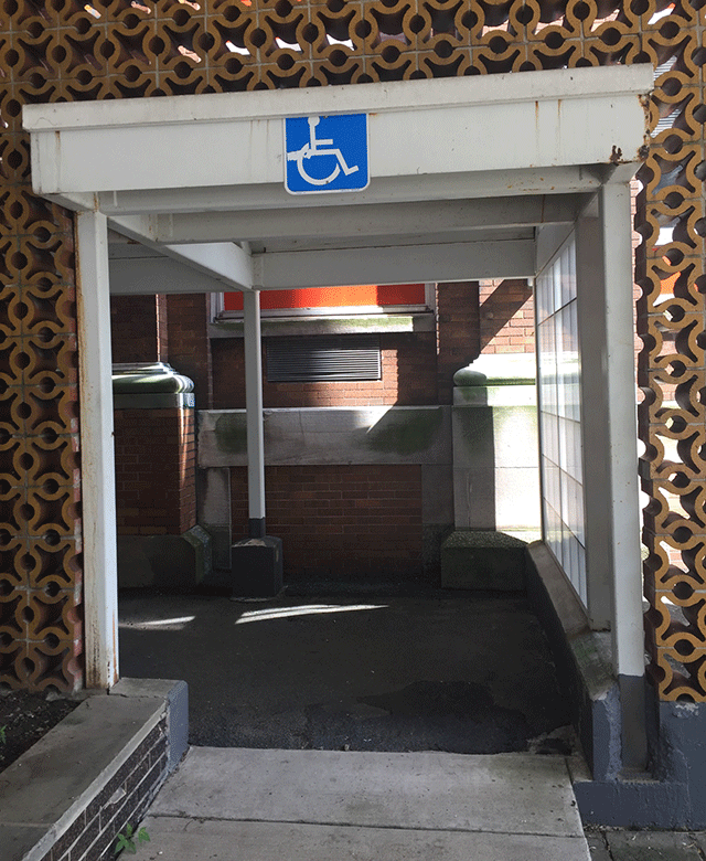 A walk way with ADA signage that leads to the building.