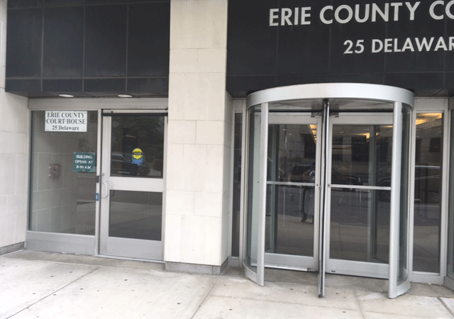 The main entrance of Erie County Court. There is a revolving door to the right and a single automatic door to the left.