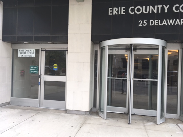 The main entrance of Erie County Courthouse. There is a revolving door to the right and a  single automatic door to the left.