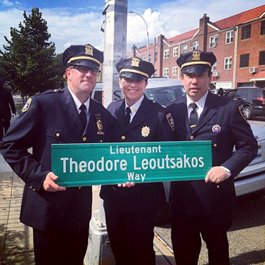 Court officers holding sign for Lieutenant Theodore Leoutsakos Way
