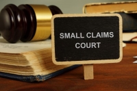 Gavel, Law Books and a sign reading "Small Claims Court"