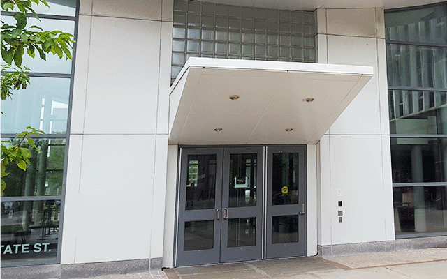 The main entrance that’s located on the street level. There is a set of double doors to the left and a single door to the right. There is a push button located on the side of the courthouse that activated the door to open. Above the entry are recessed lighting.