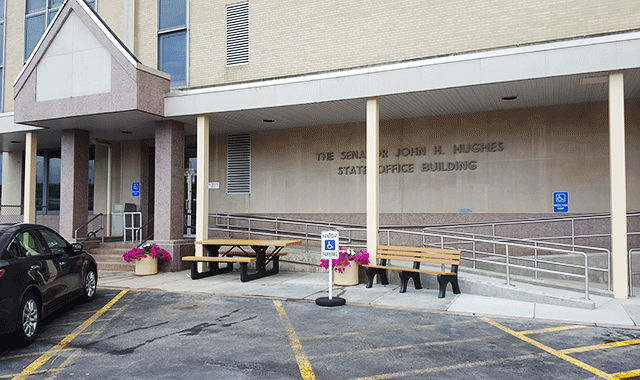 The entrance from the parking lot. There is ADA-accessible parking directly in front of the entry way. There are steps that lead to the door and a ramp to the right.