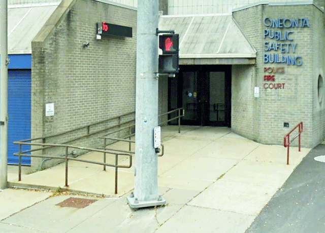 A full view of the entrance to the courthouse. There are two doors. There is a ramp on the sidewalk that leads to the left door that has ADA signage.