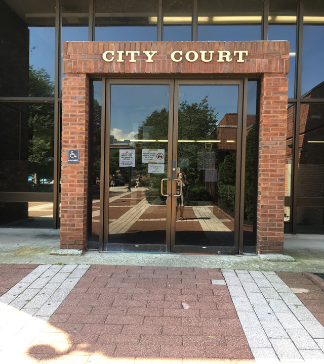 Entrance to City Court. The double door entrance is accessed from street level and has ADA signage on the left side of the building.