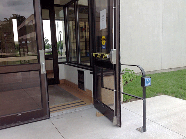 There are two double doors that can be accessed from the sidewalk. There is a push button to the right side that will open the right door.