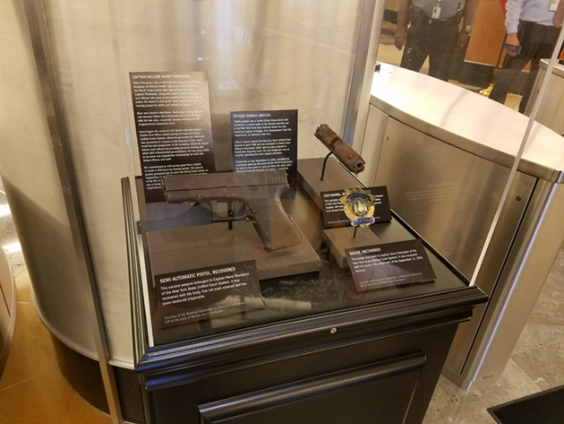 badge and firearms in display case